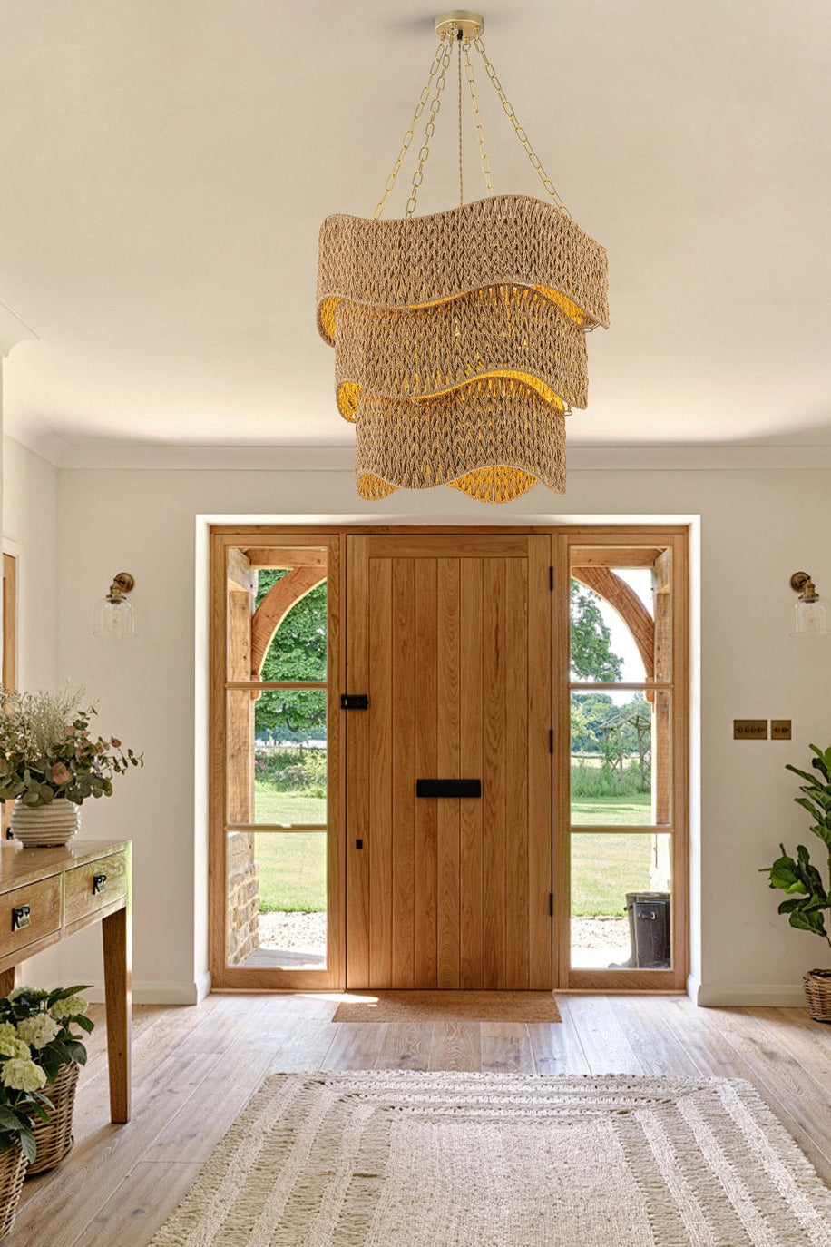 Front hallway with wooden door, decorative lamp, and plants