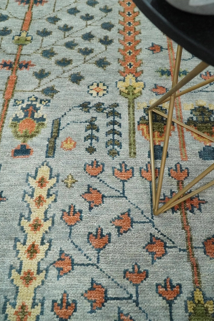 Close-up of a patterned rug with floral designs on a light blue background.